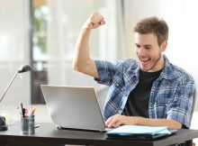 Distance learning college student triuphing with raised fists